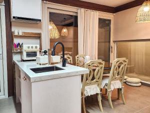 a kitchen with a sink and a counter with chairs at Relax House in Gyeongju