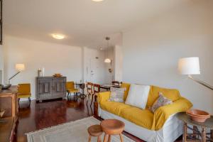 ein Wohnzimmer mit einem gelben Sofa und einem Tisch in der Unterkunft Funchal bay view Vista Mar I in Funchal