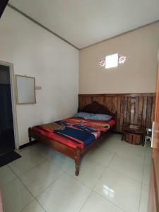 Senduro的住宿－Bali Ciliek Homestay，卧室位于客房的角落,配有一张床