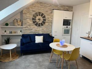 uma sala de estar com um sofá azul e uma mesa em Appartement « My love » em Sainte-Savine