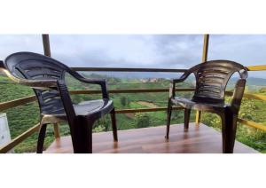 2 stoelen op een balkon met uitzicht bij The Legian 4 BHK in Ooty