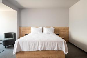 a bedroom with a white bed and a chair at BET25 Hotel in Batumi