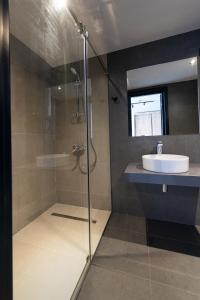 een badkamer met een glazen douche en een wastafel bij BET25 Hotel in Batoemi