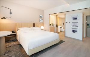 a bedroom with a bed and a desk and a mirror at Sheraton Abu Dhabi Hotel & Resort in Abu Dhabi