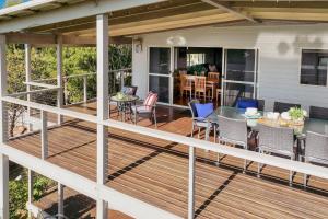 a deck with a table and chairs on a house at Salt Water in Mollymook