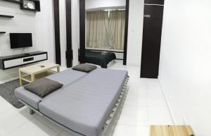 a bedroom with a bed and a tv in it at Shawn Akademic Suites Pool View @ Mount Austin in Johor Bahru