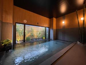 una grande piscina in una stanza con una grande finestra di Hotel Route Inn Kyoto Kameoka a Kameoka