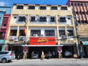 un edificio en una calle con coches aparcados delante en New Kong's Hotel en Olongapo