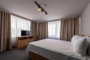 ein Hotelzimmer mit einem Bett und einem TV in der Unterkunft BET25 Hotel in Batumi