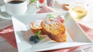 a white plate with bread and fruit and a cup of coffee at Kobe Sannomiya Tokyu REI Hotel in Kobe