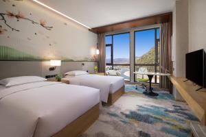 Postel nebo postele na pokoji v ubytování Hilton Garden Inn Nujiang + 27 fotografií