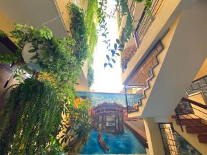 a painting on the ceiling of a building with plants at THE VIEW HOMESTAY HỘI AN in Hoi An