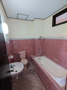 a bathroom with a tub and a toilet and a sink at Celebbest in Kuta