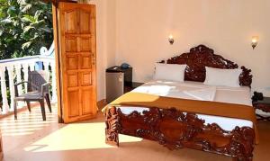 a bedroom with a large bed with a wooden frame at FabExpress VT Resort With Pool, Calangute Beach in Calangute