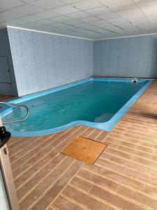 a large swimming pool in a room with a wooden floor at EL REFUGIO DE MAURO in El Campello