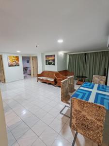 a living room with a table and chairs and a couch at 2 mins to beach Apartment 3 rooms in Pasir Bogak