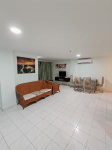 a large living room with a couch and chairs at 2 mins to beach Apartment 3 rooms in Pasir Bogak