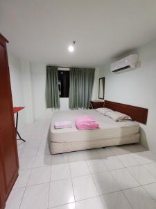 a bedroom with a bed with pink sheets on it at 2 mins to beach Apartment 3 rooms in Pasir Bogak