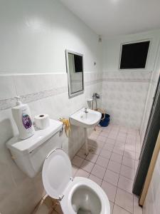 La salle de bains est pourvue de toilettes et d'un lavabo. dans l'établissement 2 mins to beach Apartment 3 rooms, à Kampong Pasir Bogak