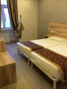 een hotelkamer met 2 bedden en een raam bij Hotel Rome Love- close to Roma Termini in Rome
