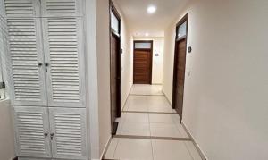 um corredor com portas brancas e pisos em azulejo em FabHotel Prime AM Suites Near Yashoda Hospital em Hyderabad