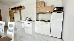 a kitchen with white cabinets and a white refrigerator at The Green Paradise Apartments in Primorsko
