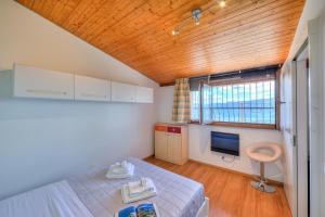 1 dormitorio con 1 cama y TV. en Petit Cadeau - Happy Rentals, en Cademario