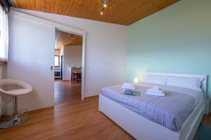 1 dormitorio con 1 cama grande y 1 silla en Petit Cadeau - Happy Rentals, en Cademario