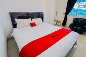 a white and red bed in a room at RedDoorz At Damai Guest House Kabanjahe in Kabanjahe