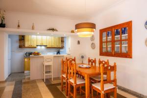 uma cozinha com uma mesa de jantar em madeira e cadeiras em Can Tiro em Costitx