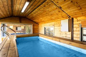 a pool in a wooden house with a wooden ceiling at Elmanzool Carmel Lodging in ‘Isfiyā