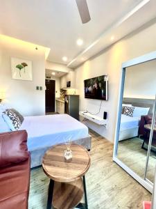 1 dormitorio con cama, sofá y mesa en Stanford Suites 3 en Silang