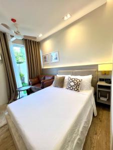 1 dormitorio con cama blanca y sofá en Stanford Suites 3 en Silang