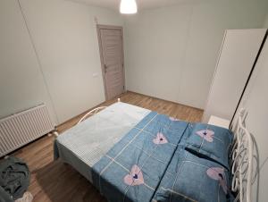 a bedroom with a blue bed with flowers on it at Sunshine Inn Buriani in Chilaantkari +14 photos