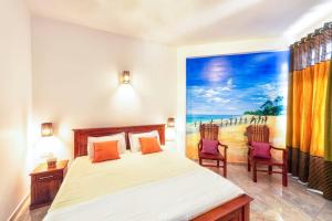 a bedroom with a bed and two chairs at Sol Y Mar - Unawatuna in Galle
