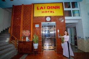 a woman standing in front of a hotel at Lai Dinh Hotel in Sầm Sơn +2 photos