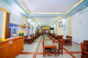 a restaurant with tables and chairs and a long corridor at Lai Dinh Hotel in Sầm Sơn