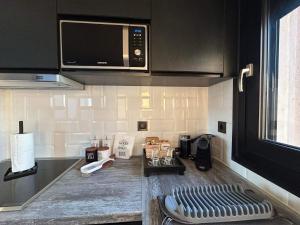a kitchen with a microwave and a counter top at Grand Kourouta in Kourouta