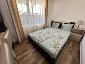 a small bedroom with a bed with a window at Вила Quiet Bay in Sozopol