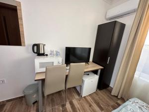 a small room with a desk with a computer and a television at Вила Quiet Bay in Sozopol