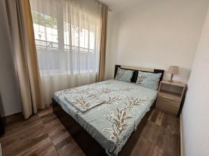 a small bedroom with a bed and a window at Вила Quiet Bay in Sozopol