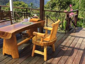 a wooden table and chair on a deck at SunRise 23.5N B&B in Fenqihu