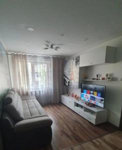 a living room with a couch and a flat screen tv at Regim hotelier Alba Iulia AmOS in Alba Iulia
