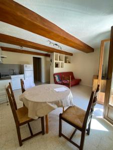 a living room with a table and chairs and a kitchen at balcon sur le lac in Bauduen
