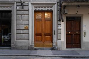 a pair of wooden doors on a building at [Station - City Center] Studio Flat in Florence