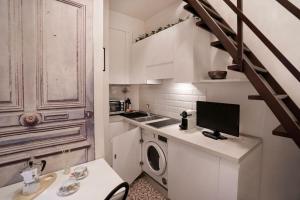a kitchen with a washing machine and a computer on a counter at [Station - City Center] Studio Flat in Florence +7 photos