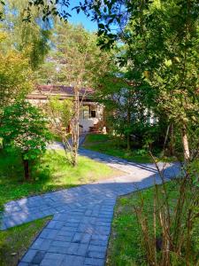 einen Kopfsteinpflasterweg in einem Garten mit einem Haus in der Unterkunft Apartamenty Atol in Pogorzelica