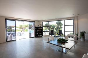 a living room with white furniture and large windows at Ostria Sea Side Hotel in Hanioti