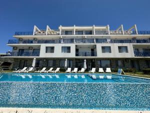 a hotel with a swimming pool in front of a building at Вила Quiet Bay in Sozopol