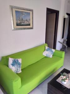 a green couch sitting in a living room at PIZZO BEACH CLUB 14F in Pizzo